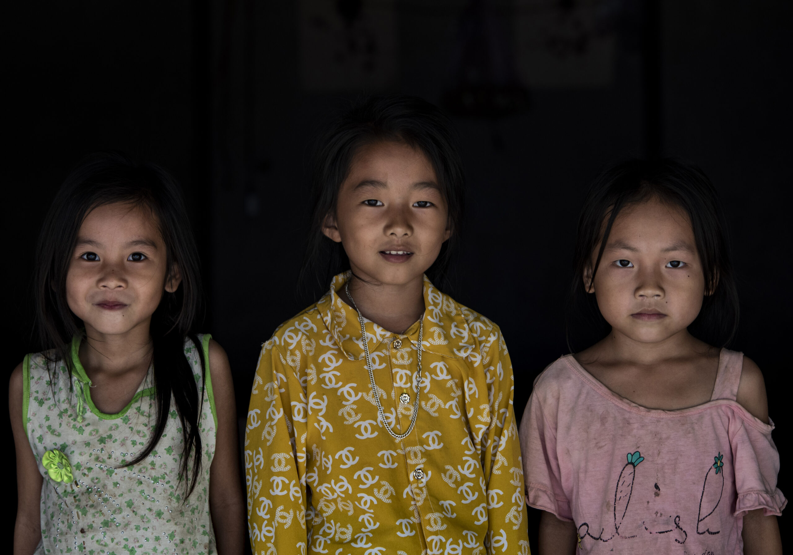 3 young girls posing in front of their house