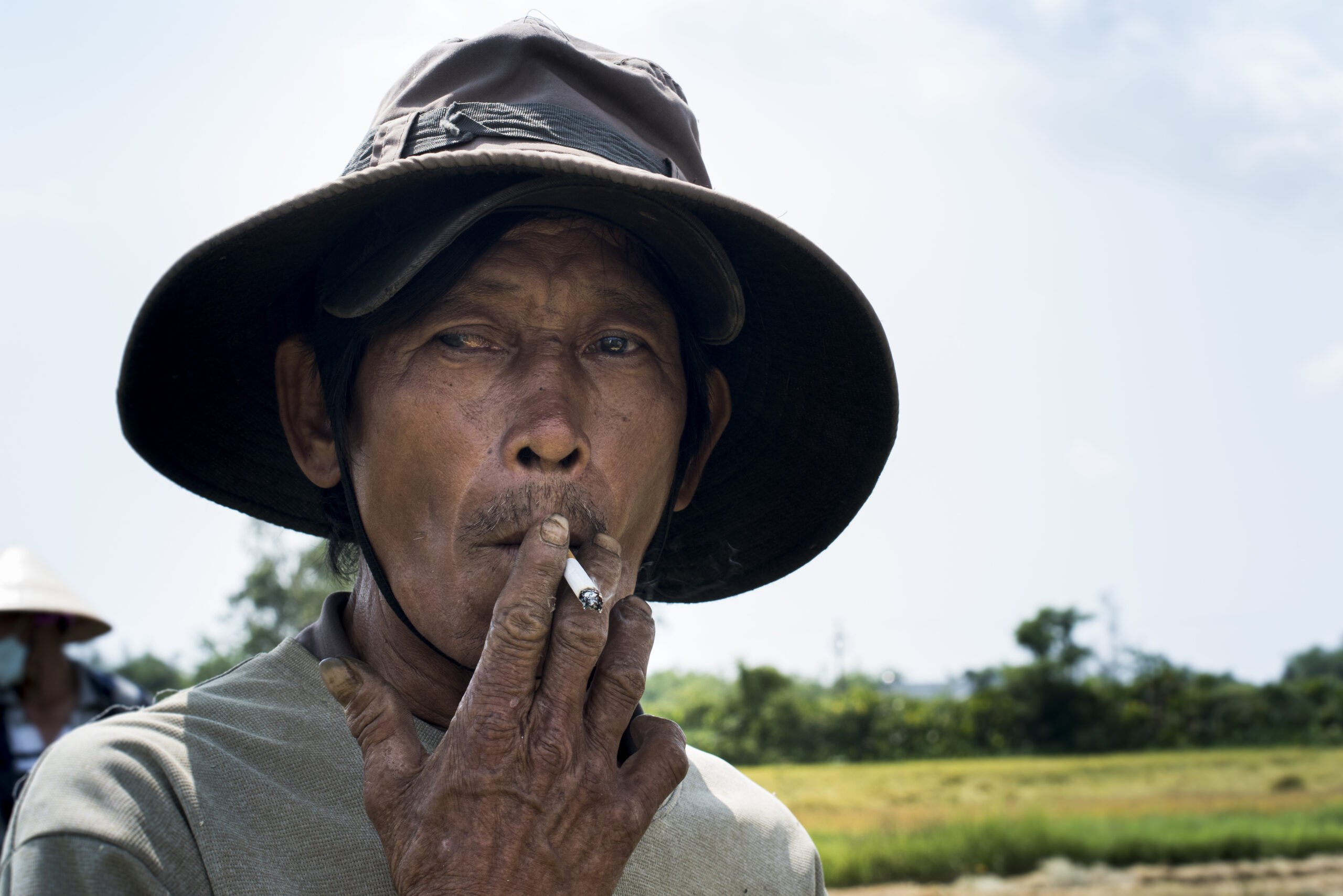 Rise field worker having a smoke during his break in Cam Kim island in